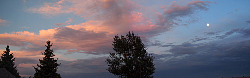 [Two photos stitched together showing open blue sky across which pink clouds are spread. In the far right is a nearly full moon.]